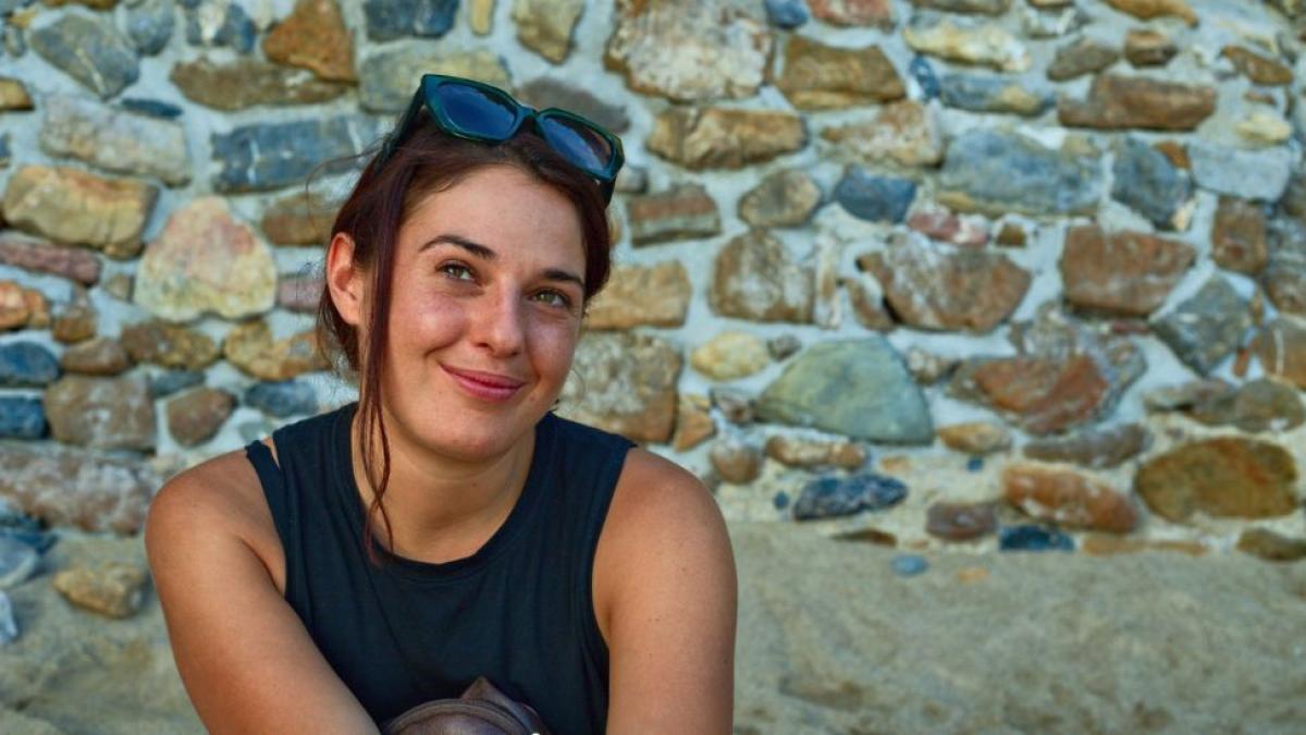 Seidenberg professor Sara Falcone posing for a photo in front of a rocky background.