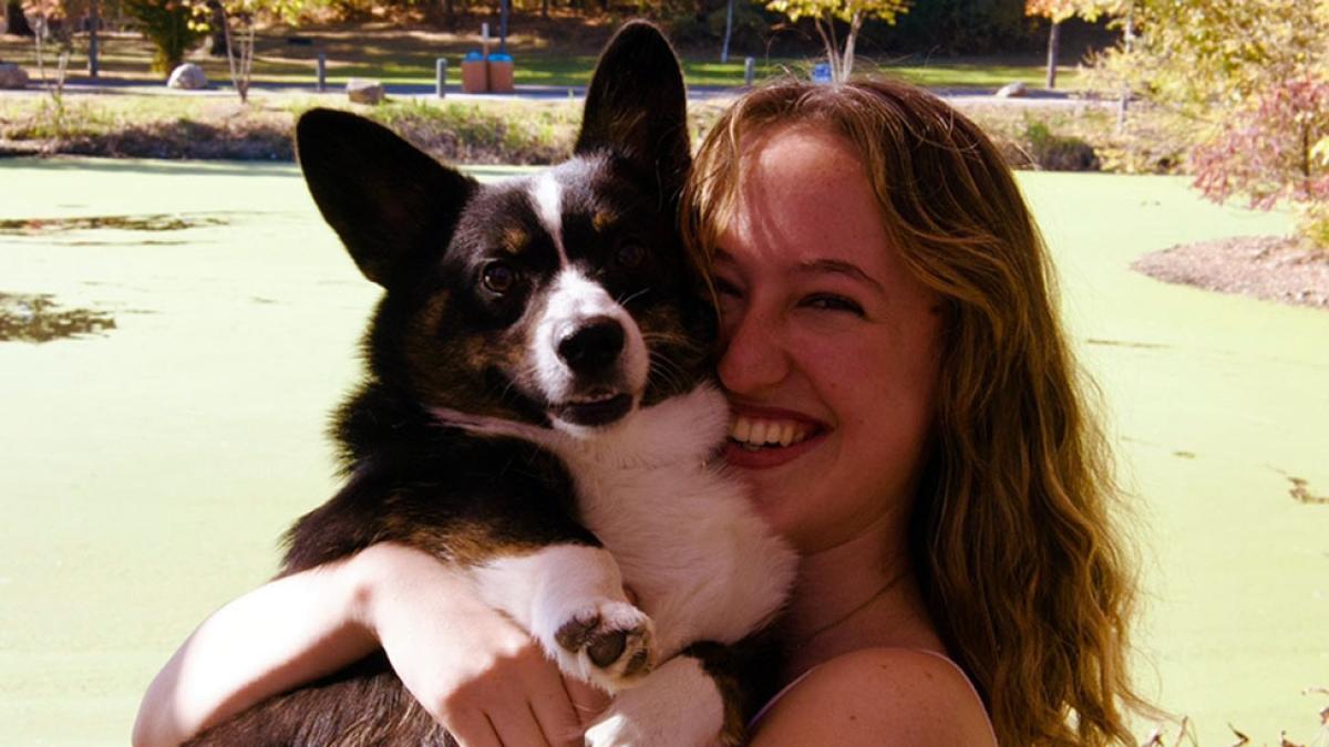 A female holding and hugging her dog