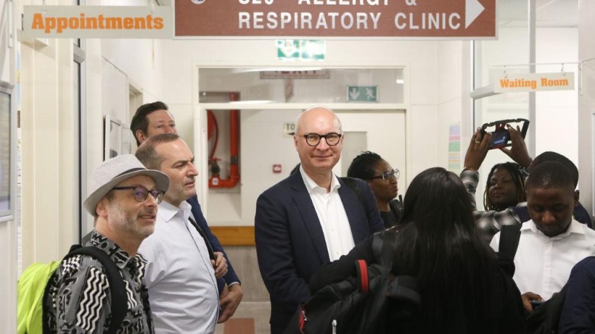 Jose Castro with journalists at respiratory clinic site visit