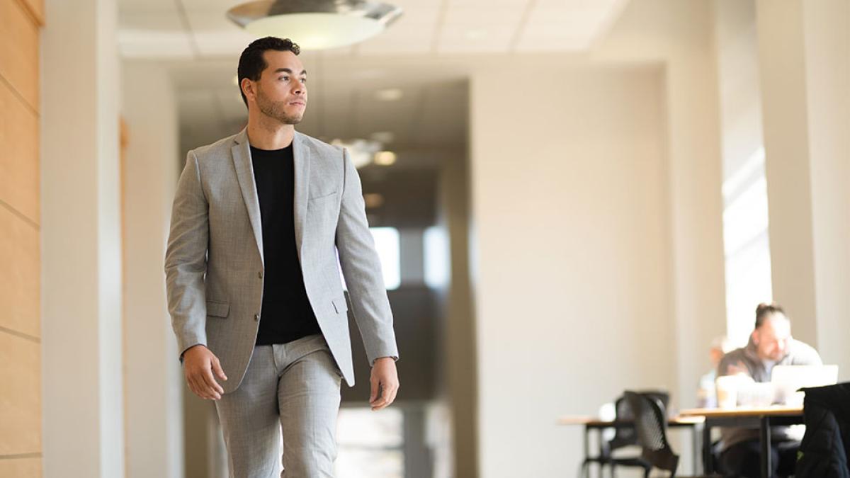 Pace University student, wearing a suit, walking around campus.