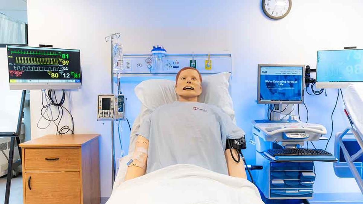 One of Pace University's College of Health Professions manikins dressed up as a patient in a hospital bed