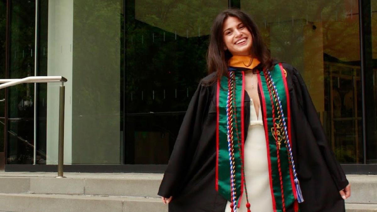 Alessandra Barretta '26 posing in her cap and gown in front of One Pace Plaza.