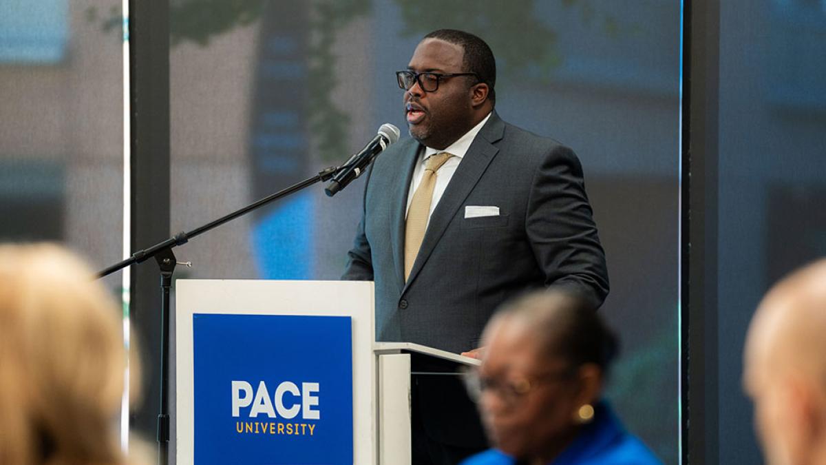 Vincent Clark at a podium speaking into a microphone.