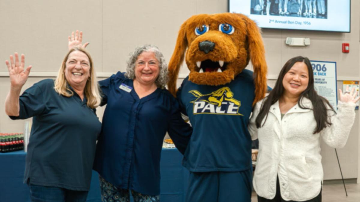 Pace University staff members posing with the school mascot, T-Bone.