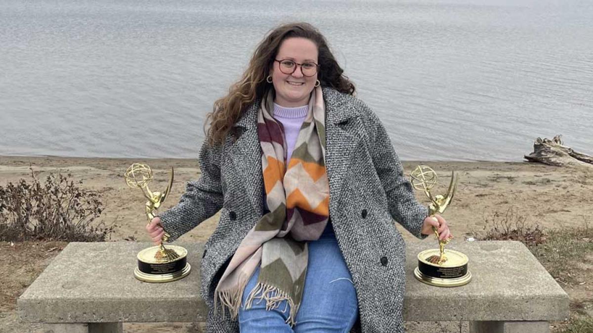 Jessika Pietrya with two of her Emmy awards in front of the Hudson River.