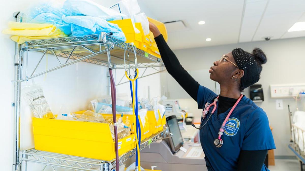 Nursing student in a classroom posing for the camera.