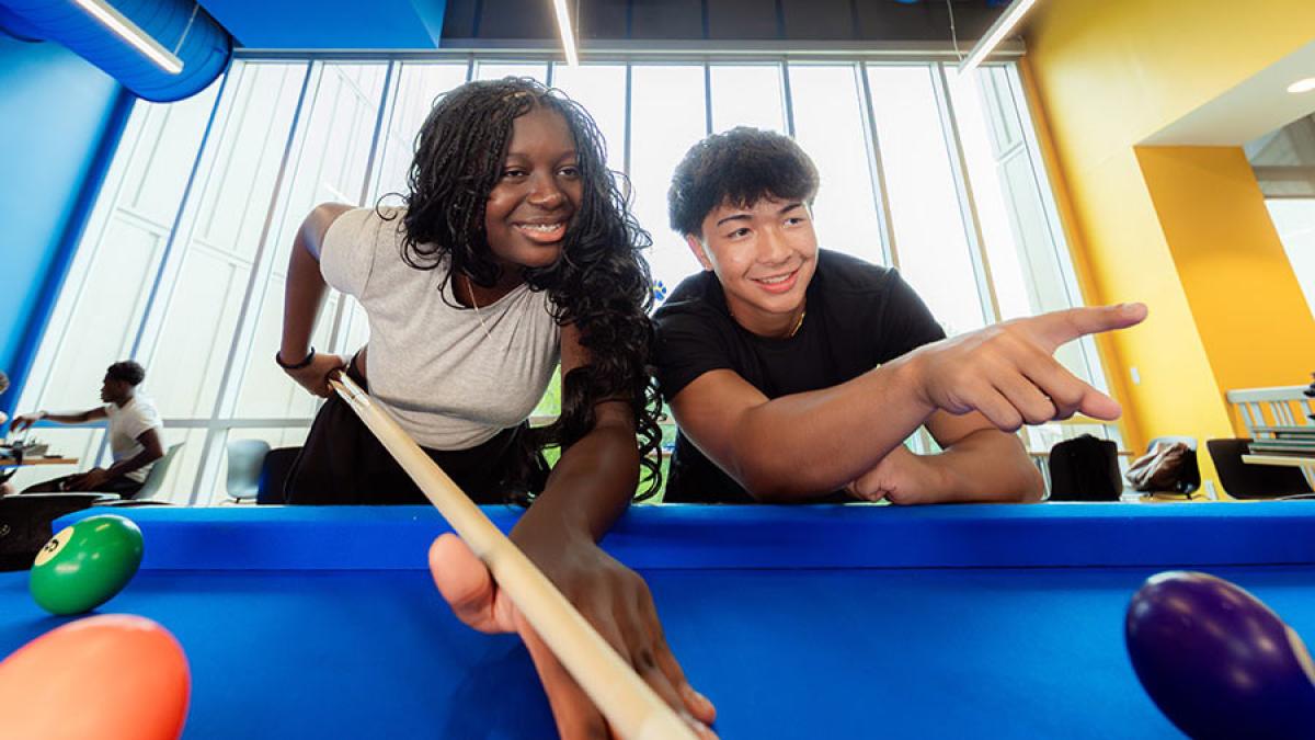 Two Pace University students playing pool on the Westchester Campus.