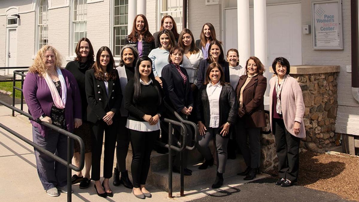 The staff of the Pace Women's Justice Center posing for a group photo in front of their building.