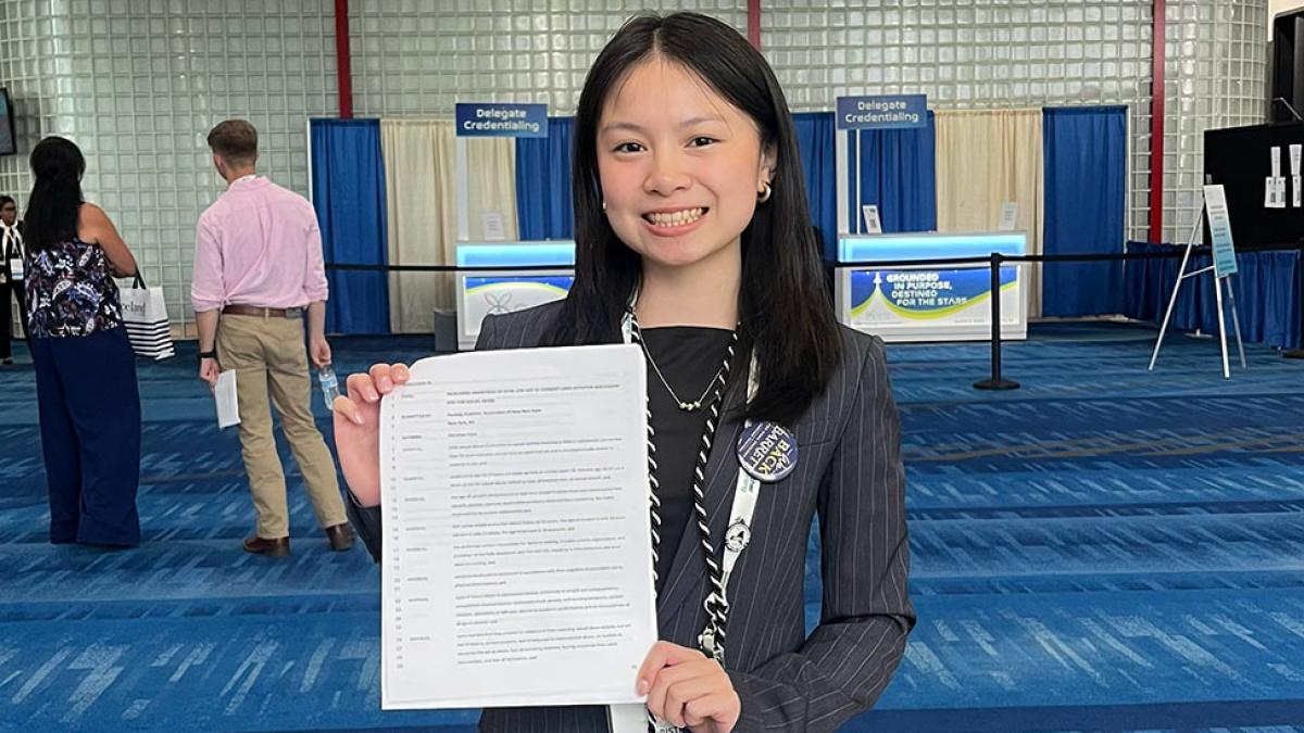 Christina Tram holding a copy of her resolution.