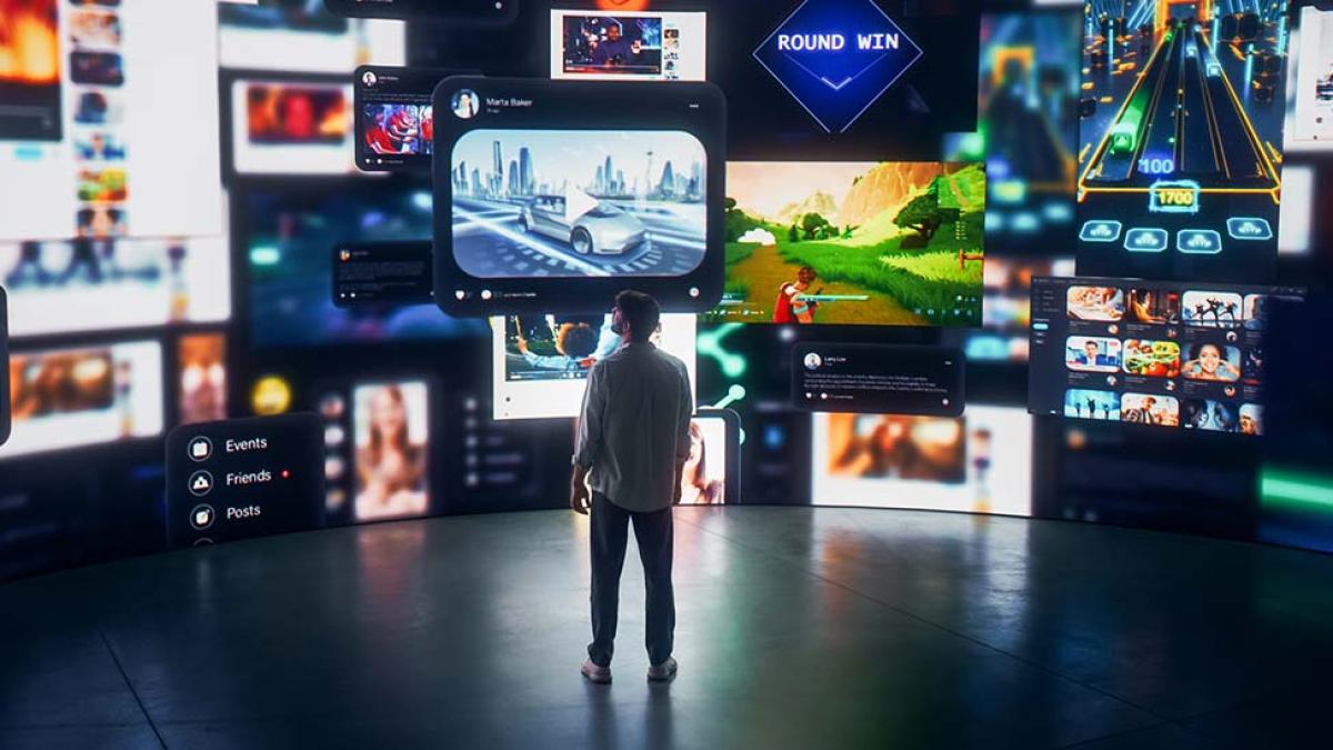 A photo of a man looking at a bunch of television screens.