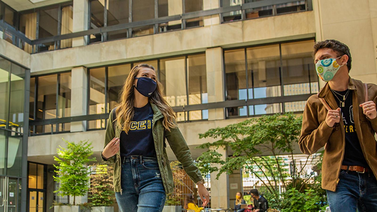 Students walking around the NYC campus wearing masks