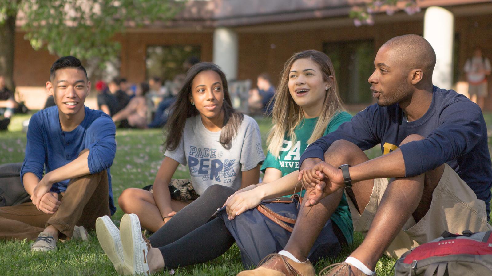 Pace students sitting in the grass, in front of Mortola Library on the Pleasantville campus