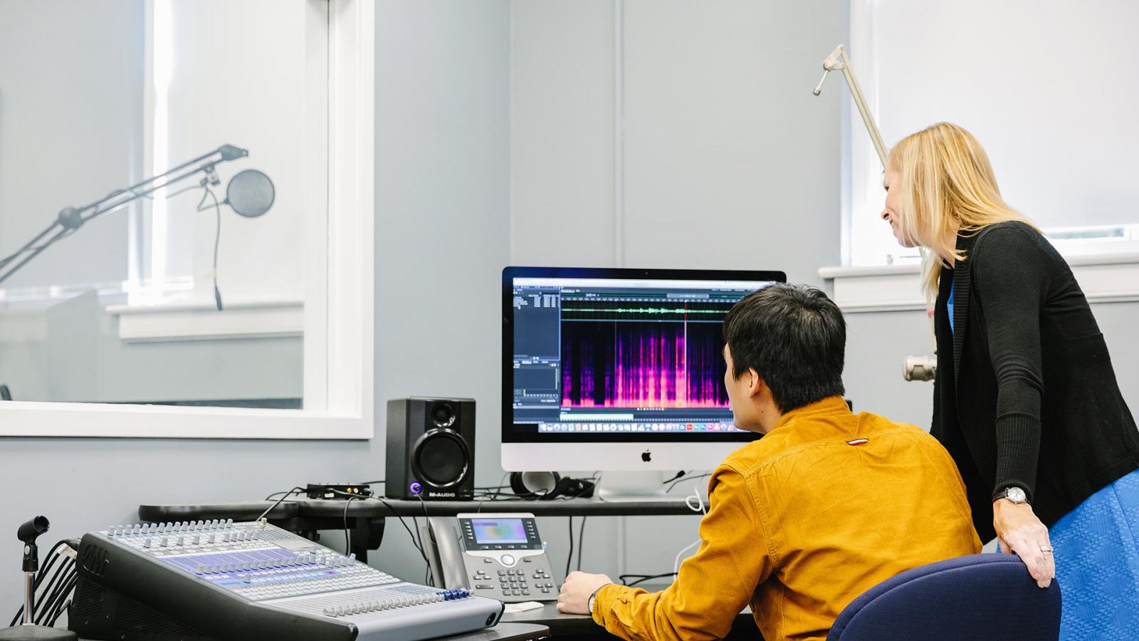 Student with professor using a computer.
