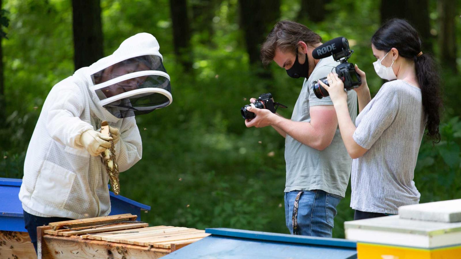 students filming a bee keeper 