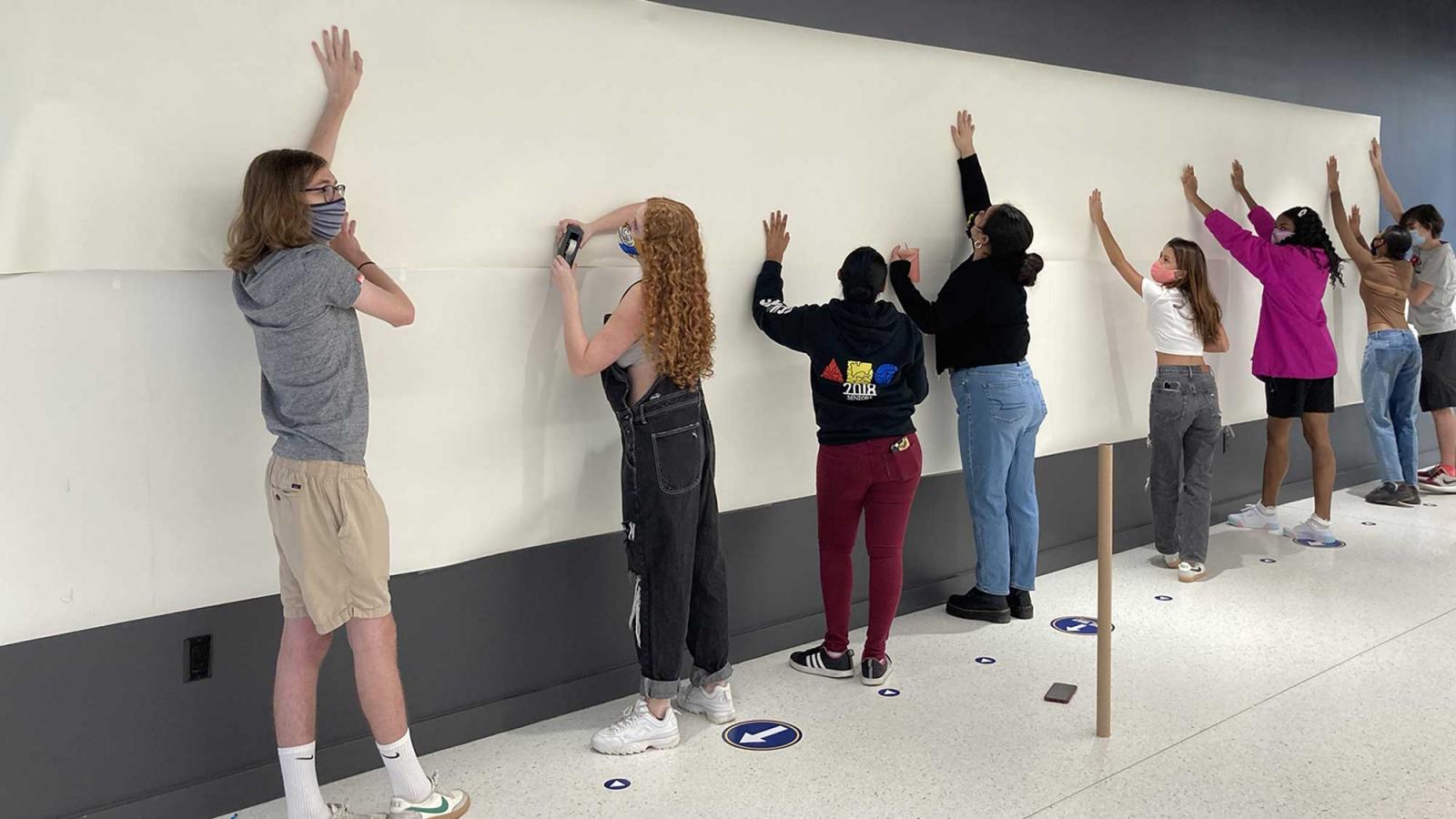 a group of students working on a mural