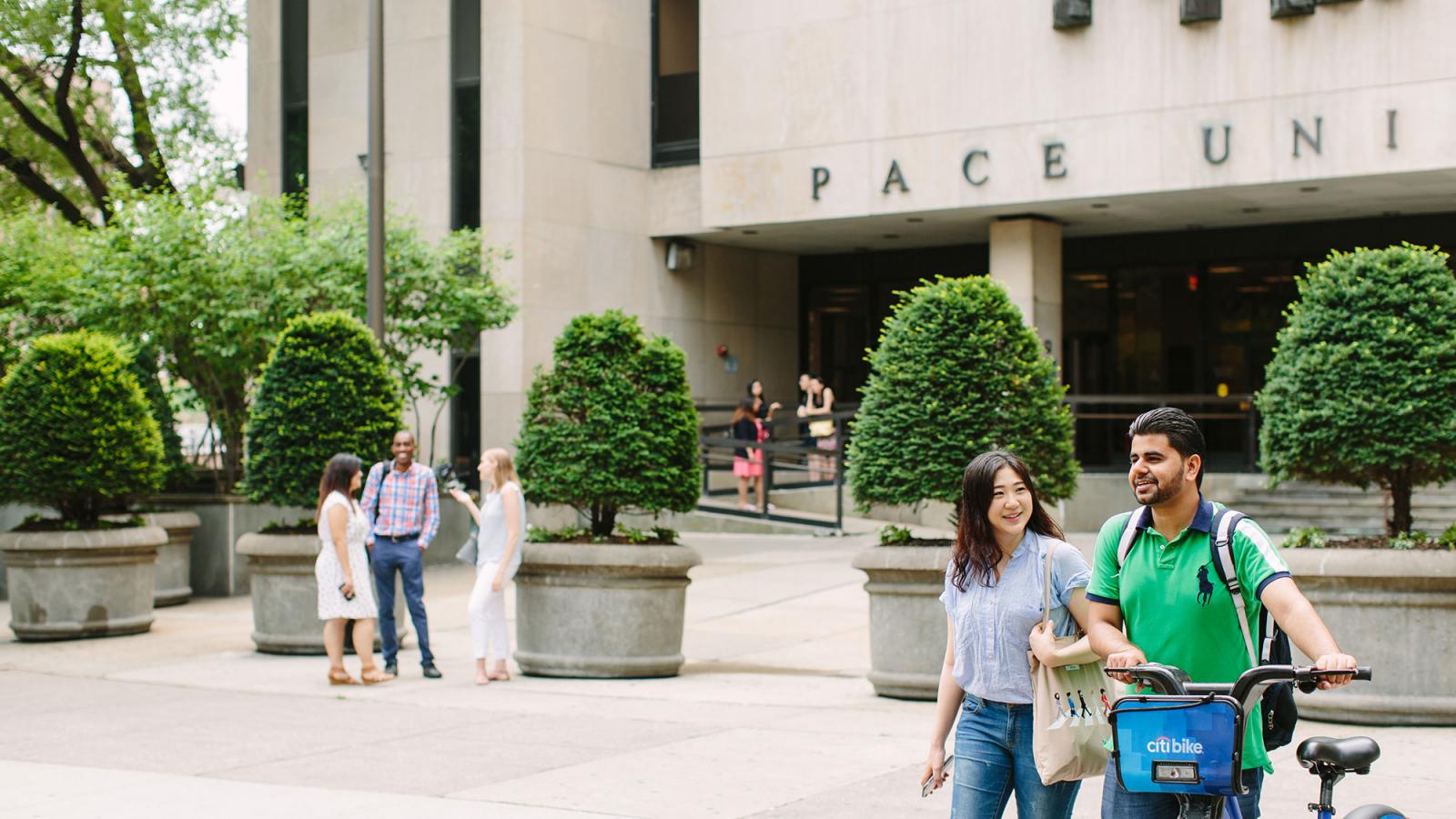 Pace University students walking in front of 1 Pace Plaza in NYC.