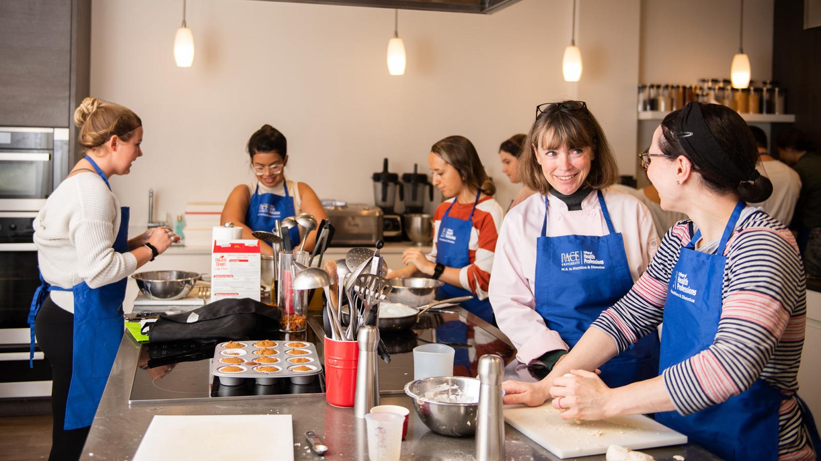 Nutrition and Dietetics graduate students working with a faculty member in the kitchen.