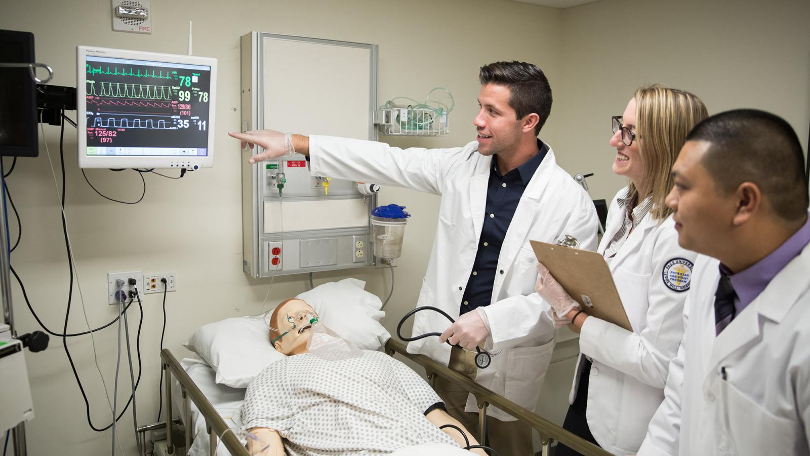 Students working with a faculty member in a clinical setting.