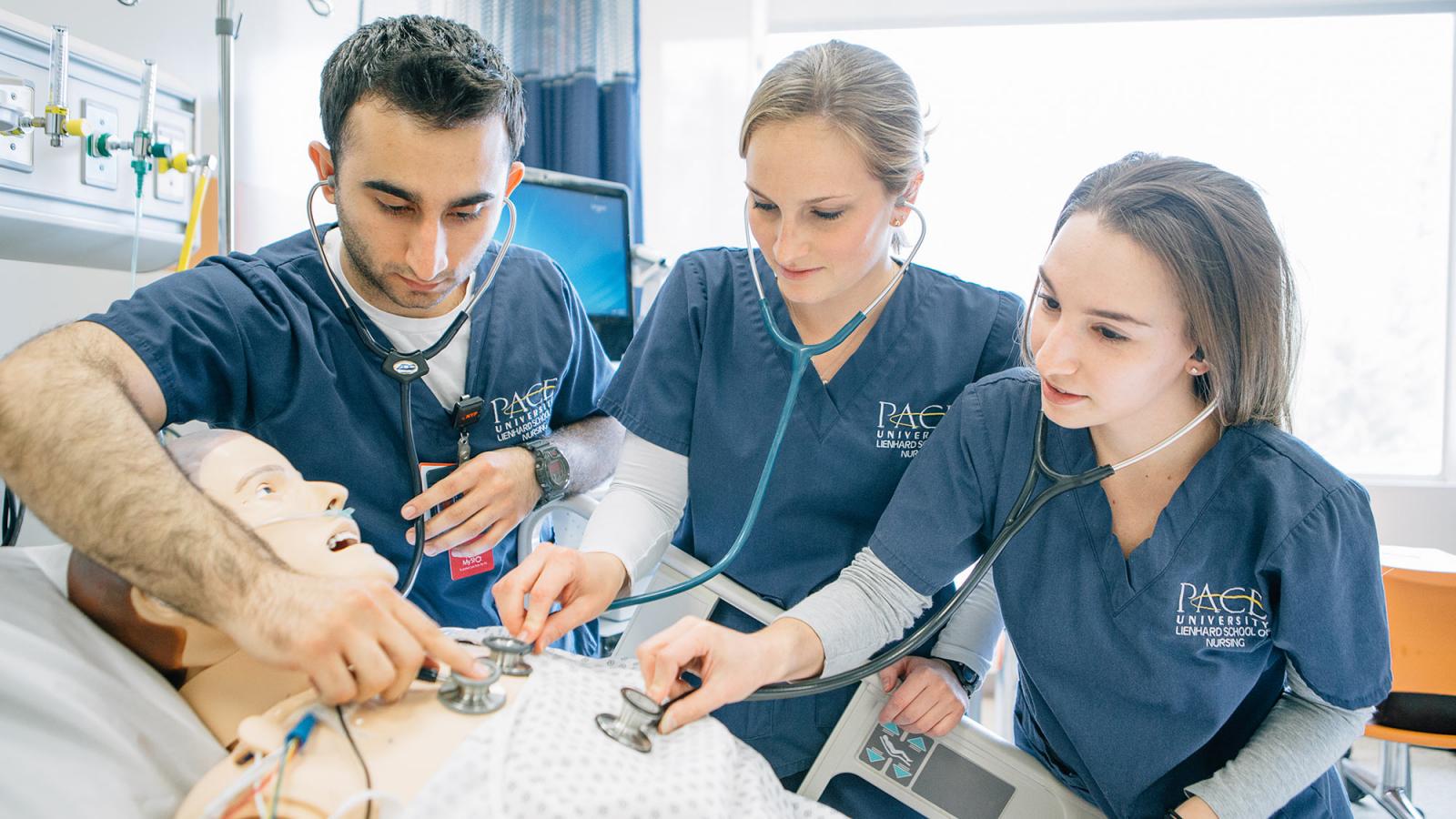 Students working on a mannequin in the simulation lab.