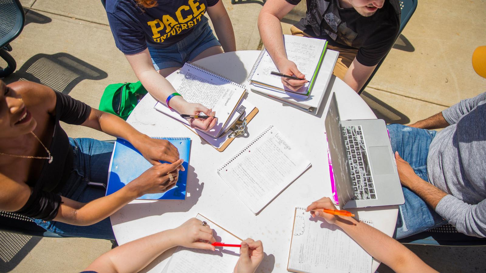 six Pace University students working collaboratively at an outdoor table on the Pleasantville campus