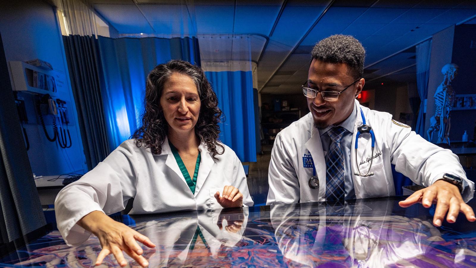 Professor working with a student on the SECTRA table.