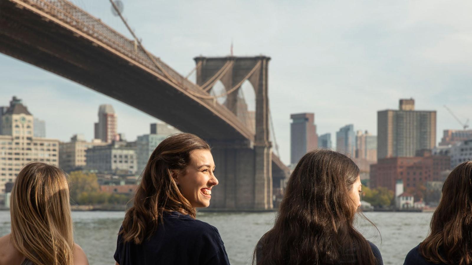 Pace University students standing in front of the Brooklyn Bridge in Manhattan