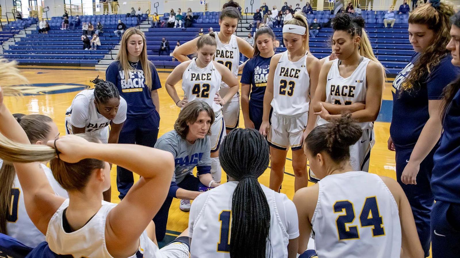 Pace coach Carrie Seymor talking to women's basketball team courtside