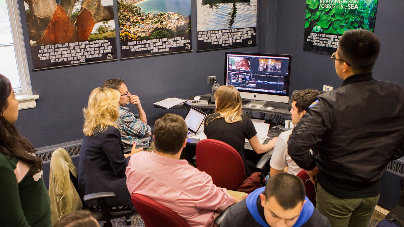 Students huddled around an iMac producing a documentary