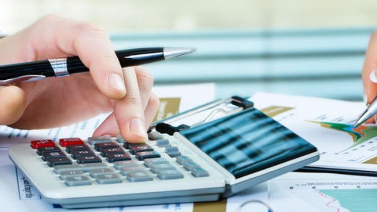 accounting department - two people doing accounting with papers and calculators