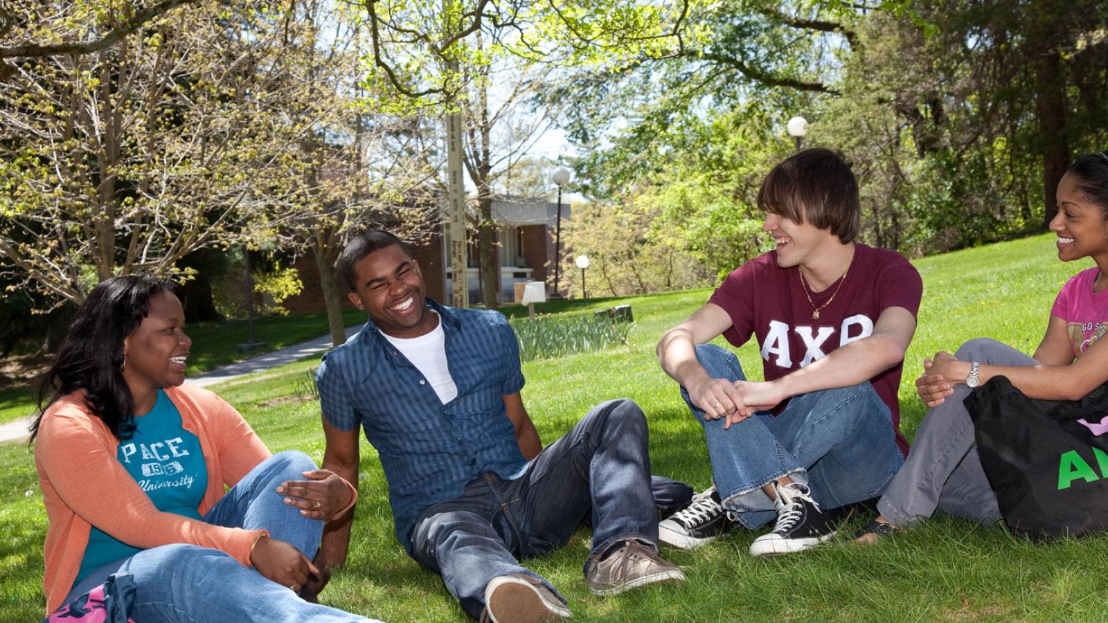 group of Pace undergraduate students sitting on the lawn of the Pleasantville Campus