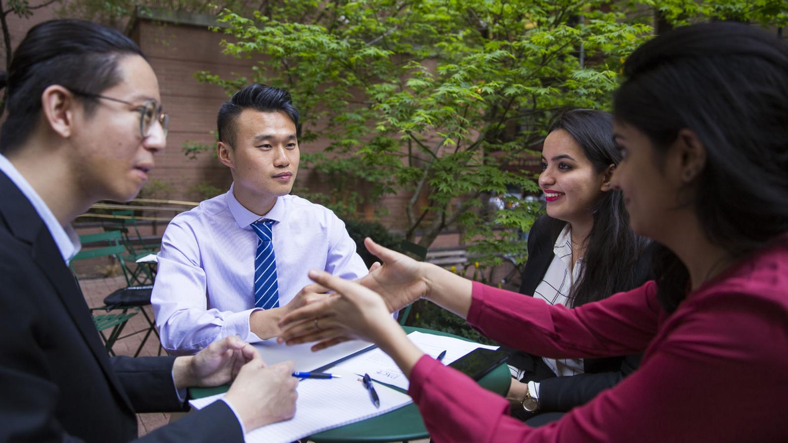 Lubin graduate students sitting at an outdoor plaza in Lower Manhattan near the New York City Campus