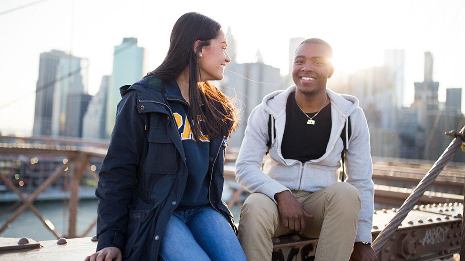 Students sitting on the Brooklyn Bridge.