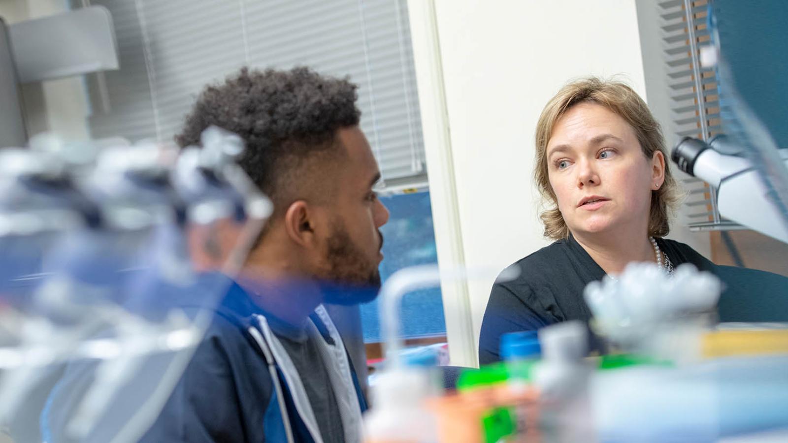 Professor talking with student in lab