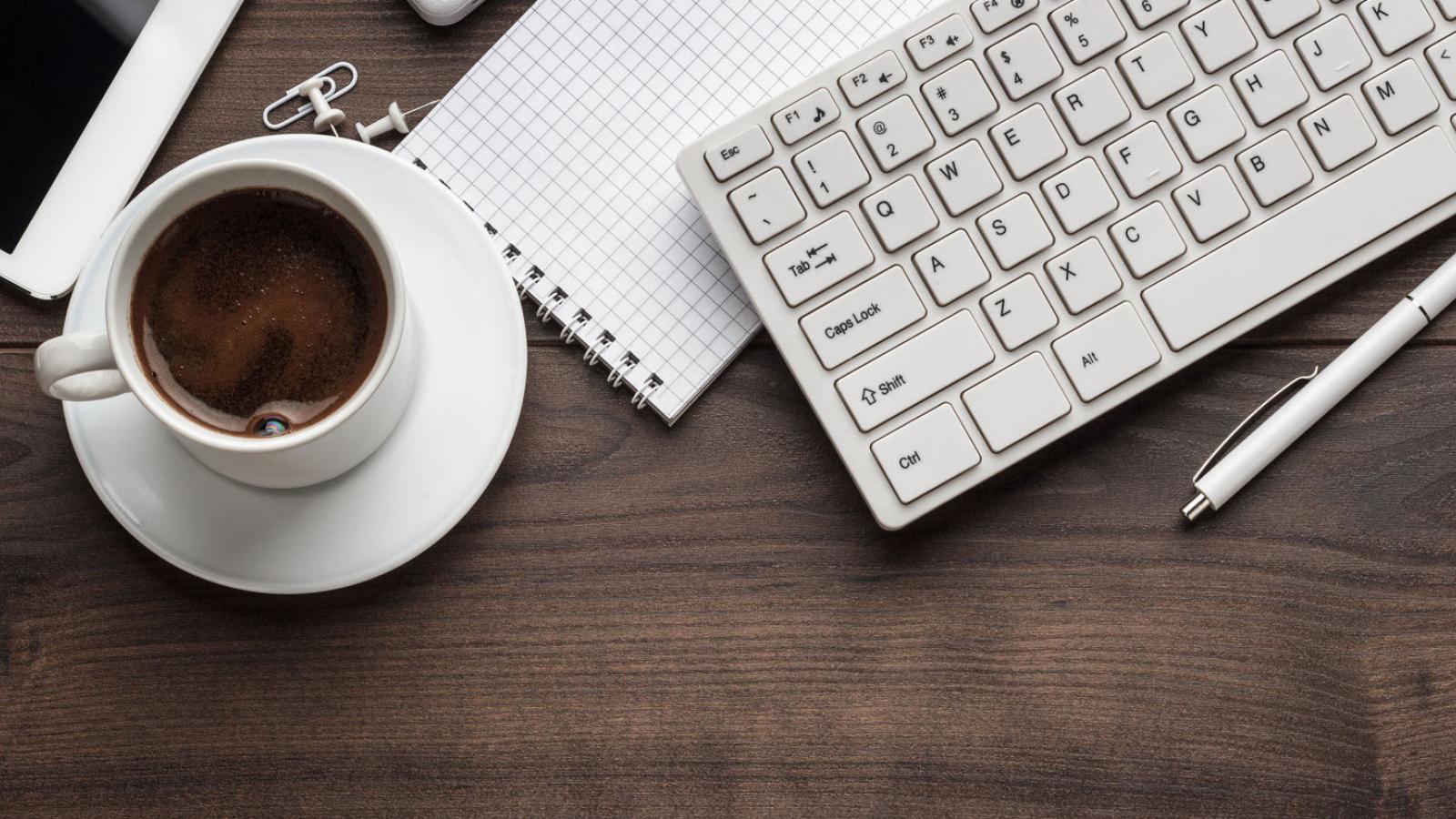 Image of a computer keyboard and coffee mug.