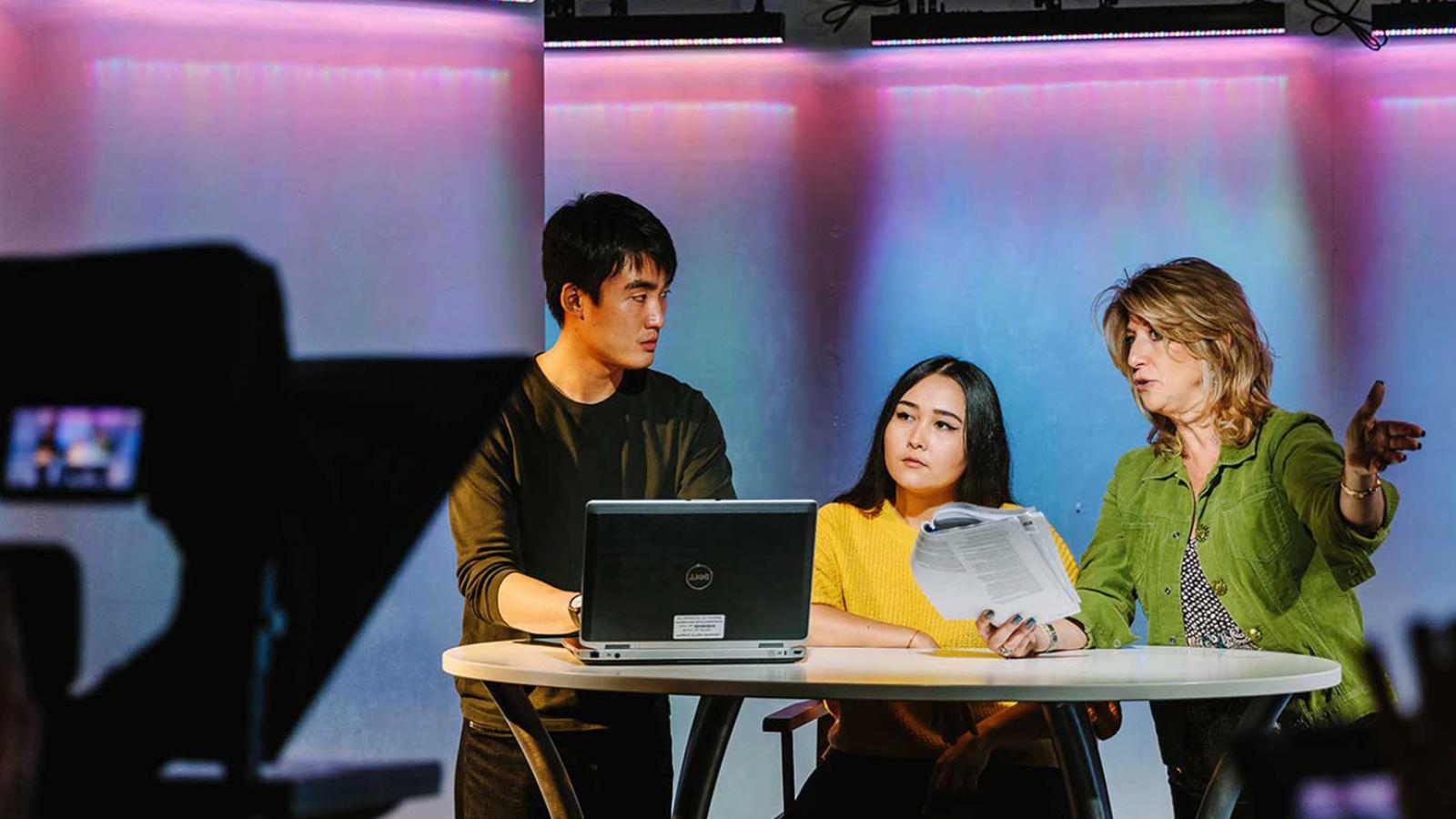 Students and professor working in a tv studio.