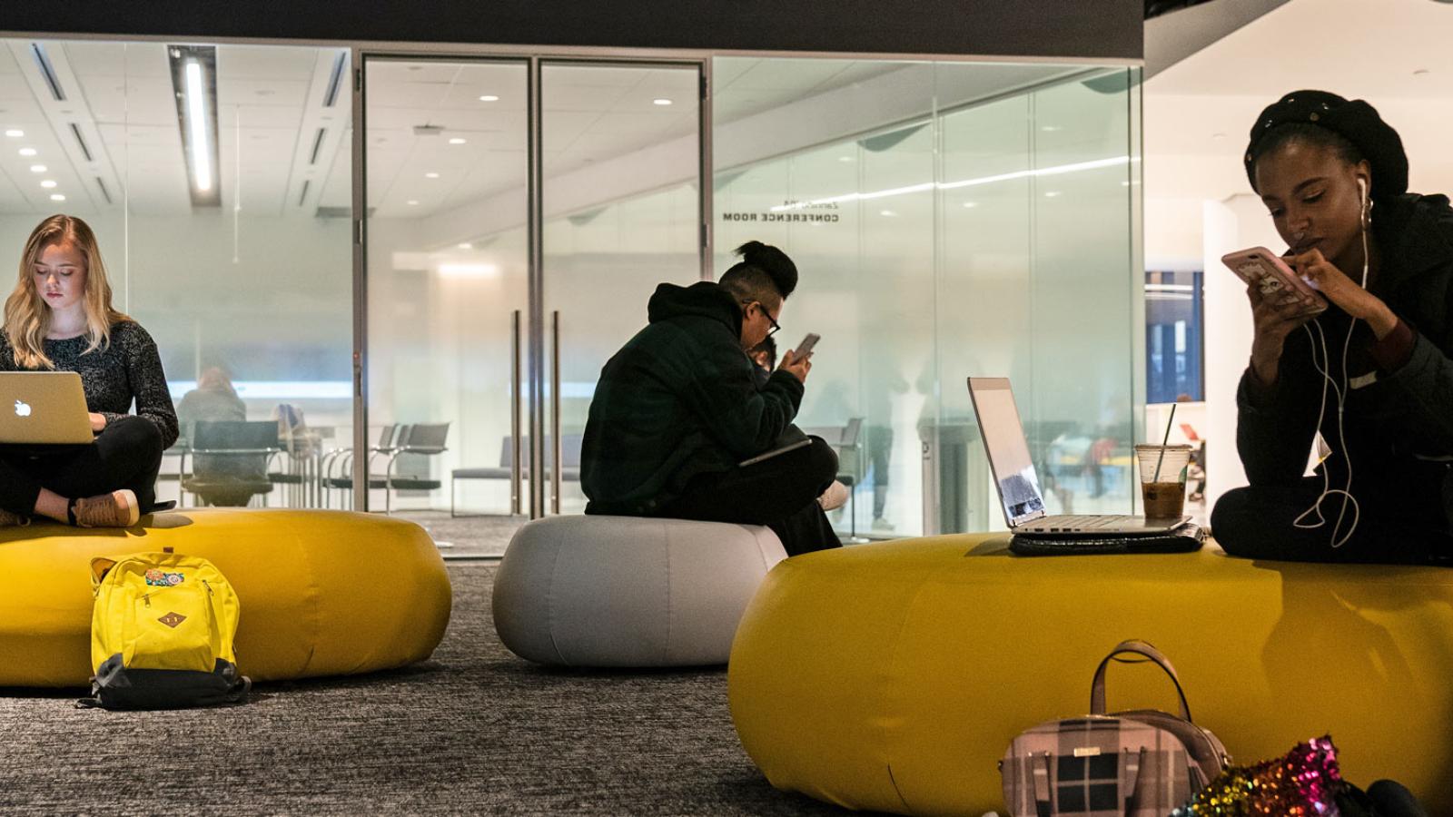 Students using computers and phones in One Pace Plaza