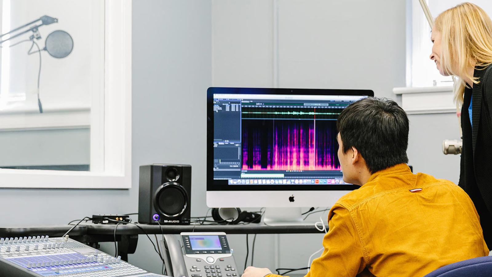 Student with professor using a computer.