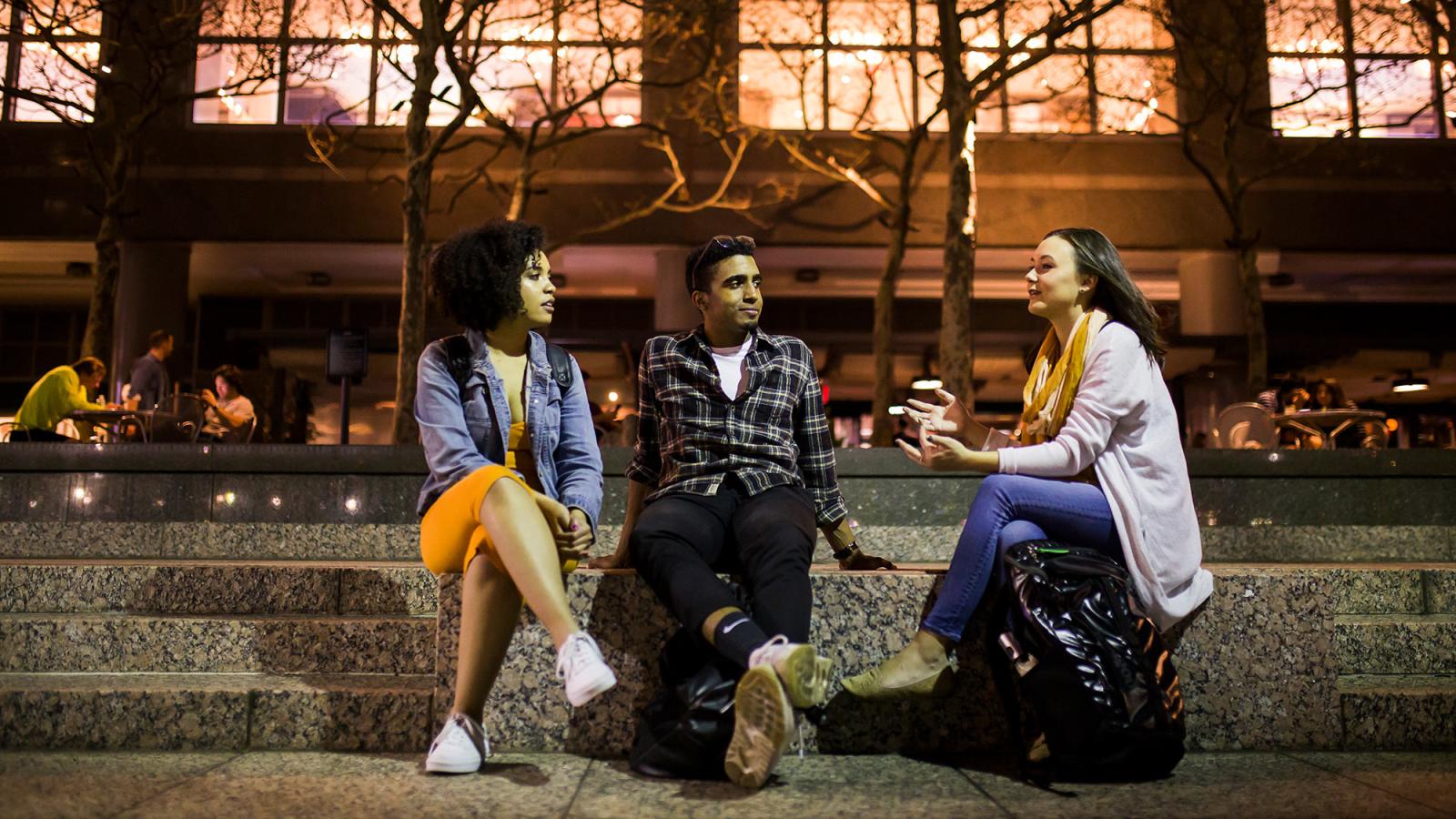 Group of students sitting on steps talking.