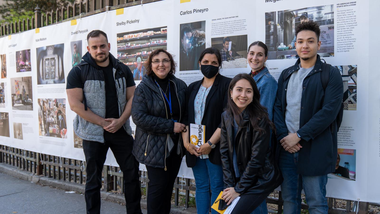 group of people in front of a photo exhibit