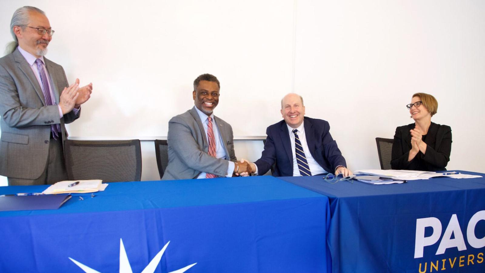 President Krislov and Dr. Anthony E. Munroe shaking hands