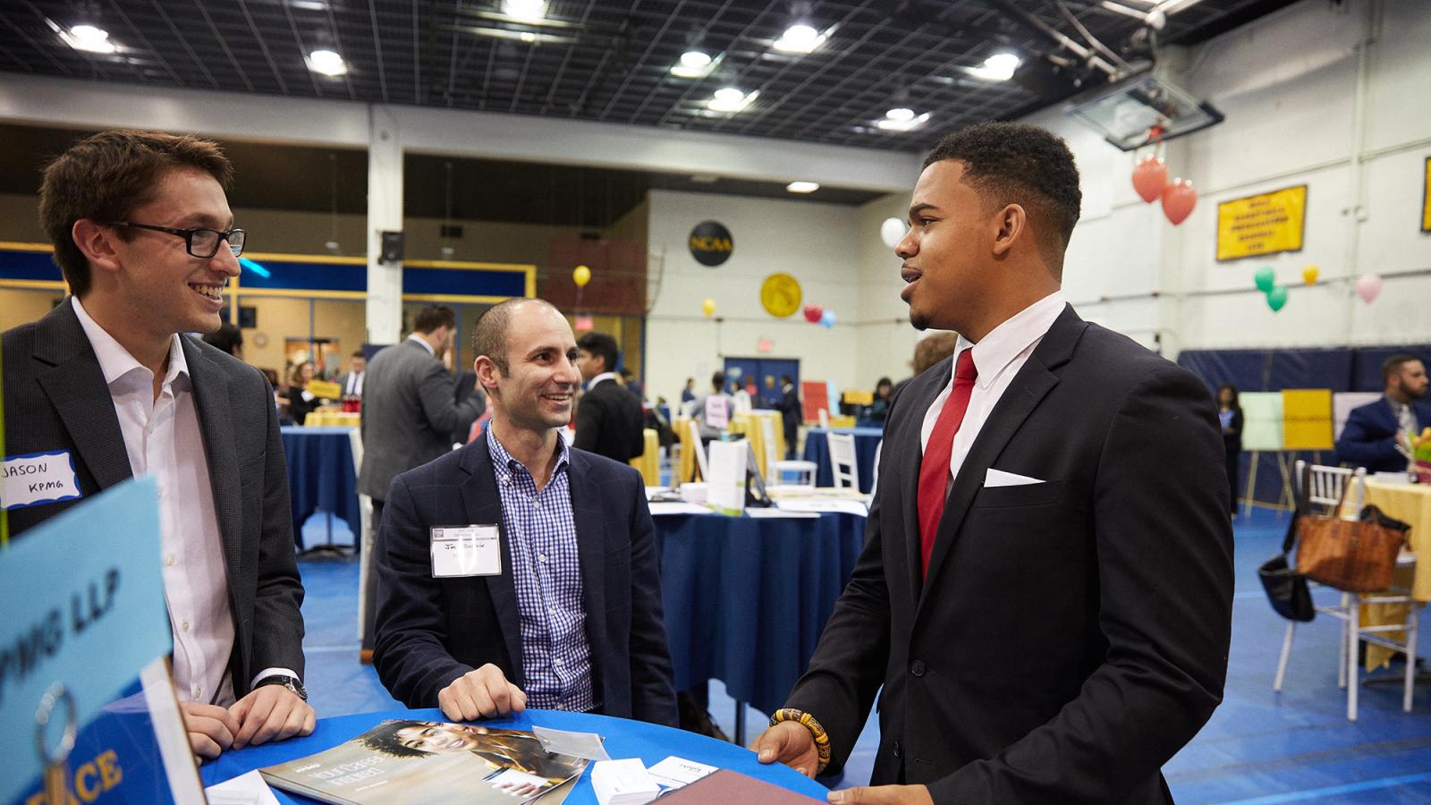 Pace University student talking to prospective employers at a career fair.