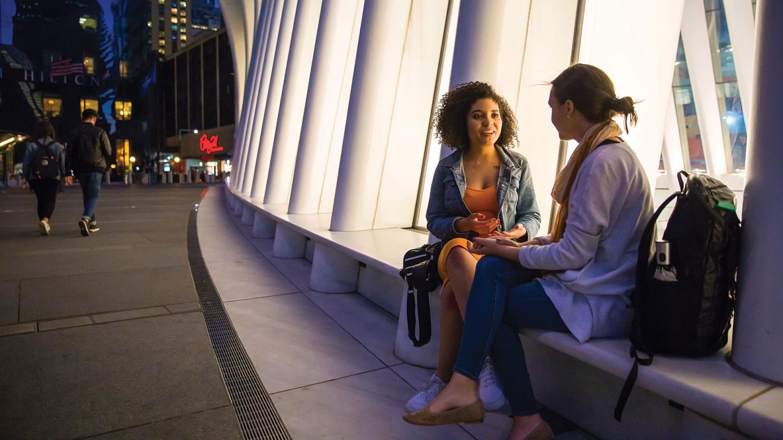 Two students sitting and talking.