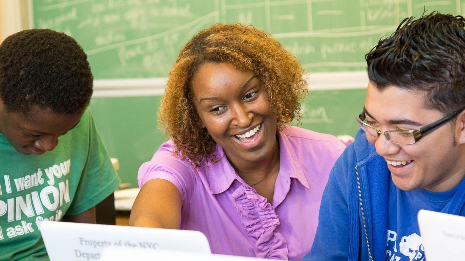 male high school students laughing with their teacher