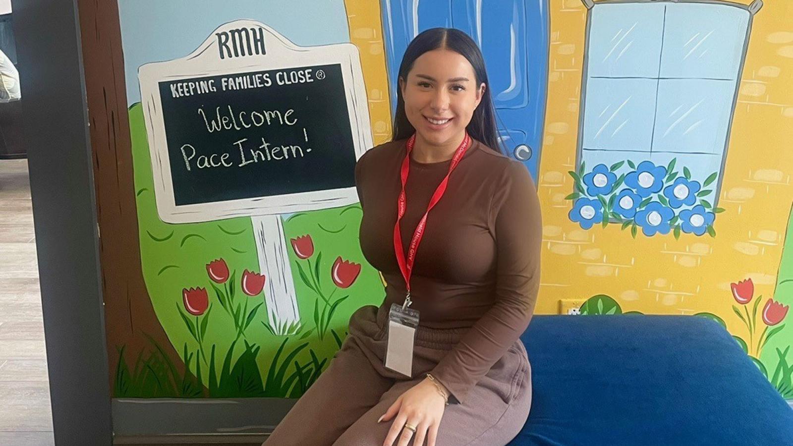 Lubin student Danielle Bellino '24 with welcome sign at her internship at the Ronald McDonald House