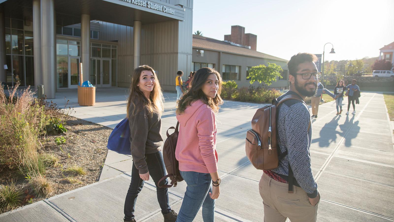 Student walking in front of the Kessel Student Center on the Westchester campus.