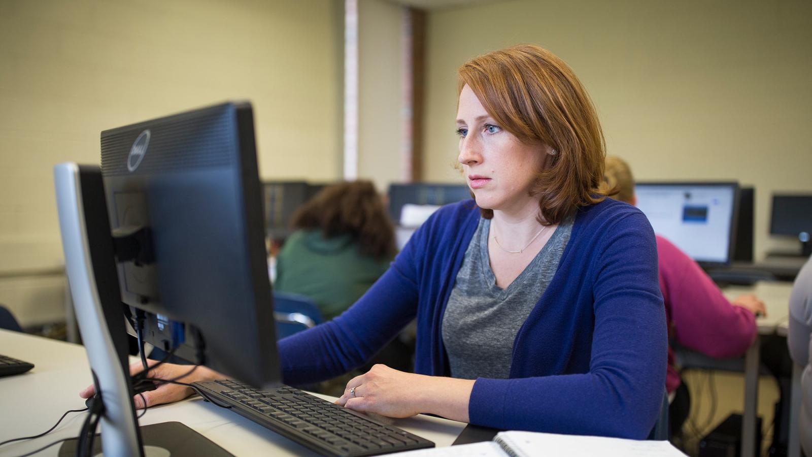 Student sitting at a desk, working on her computer.