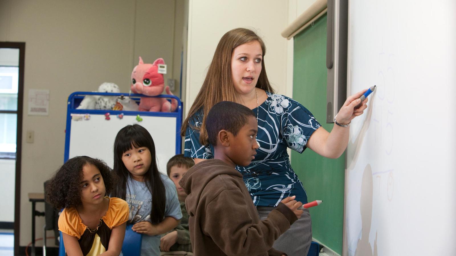 Student teacher working in a classroom environment with young students.