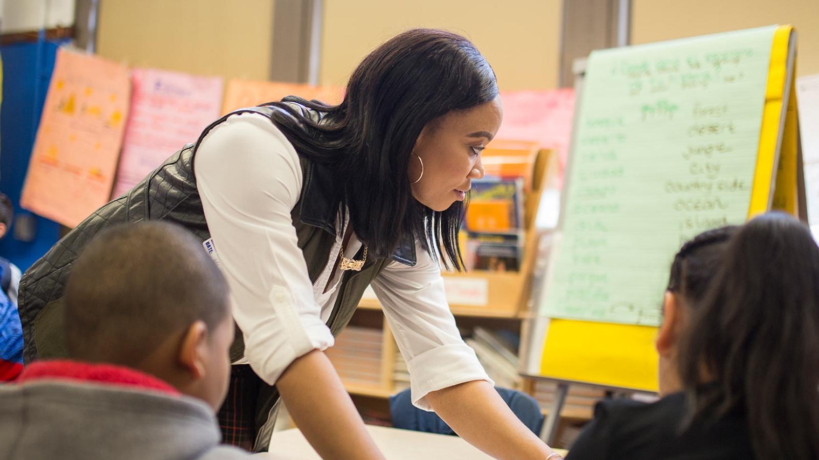 Student working with children in a classroom setting.