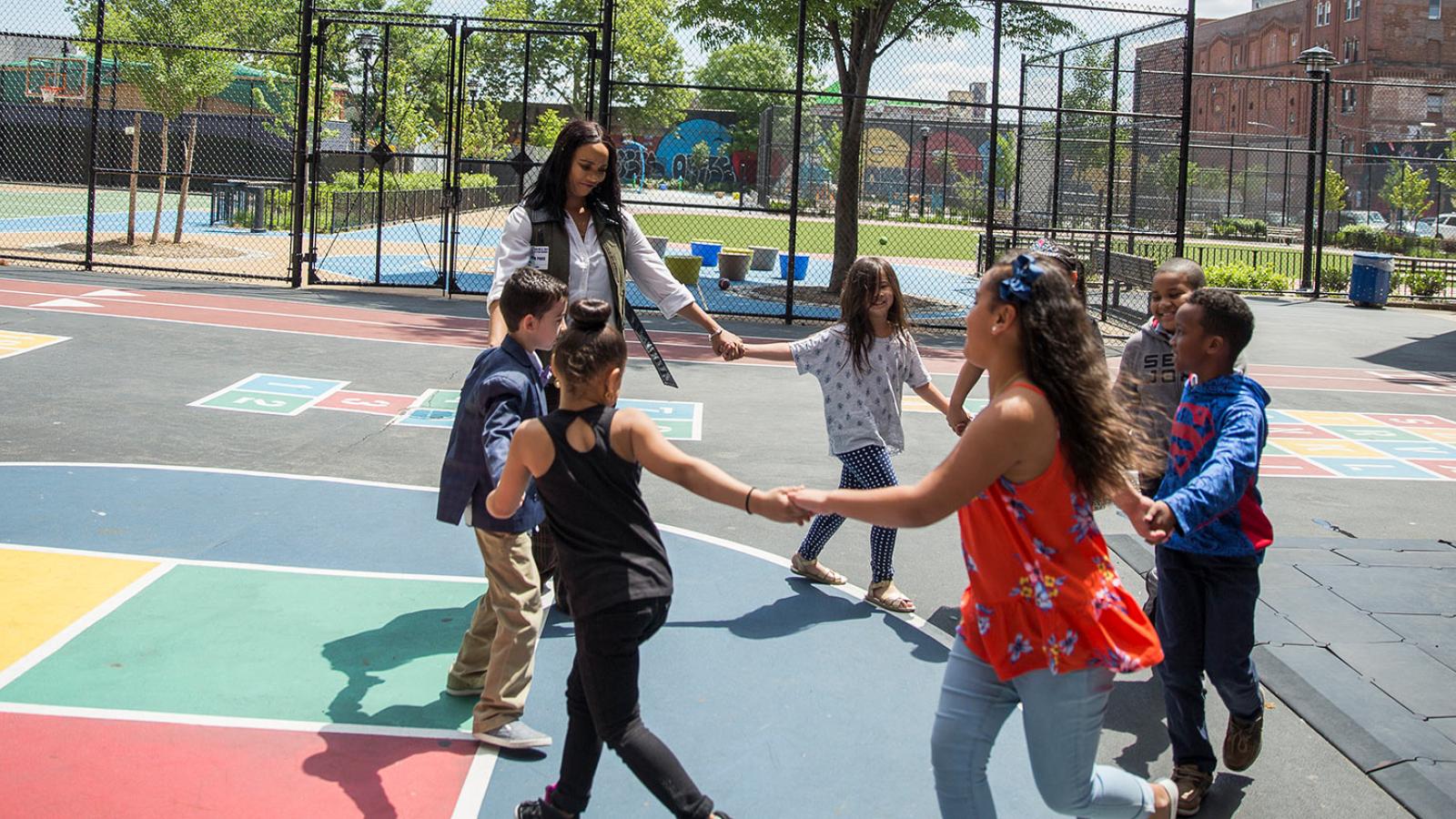 Teacher playing with the children outside during recess.