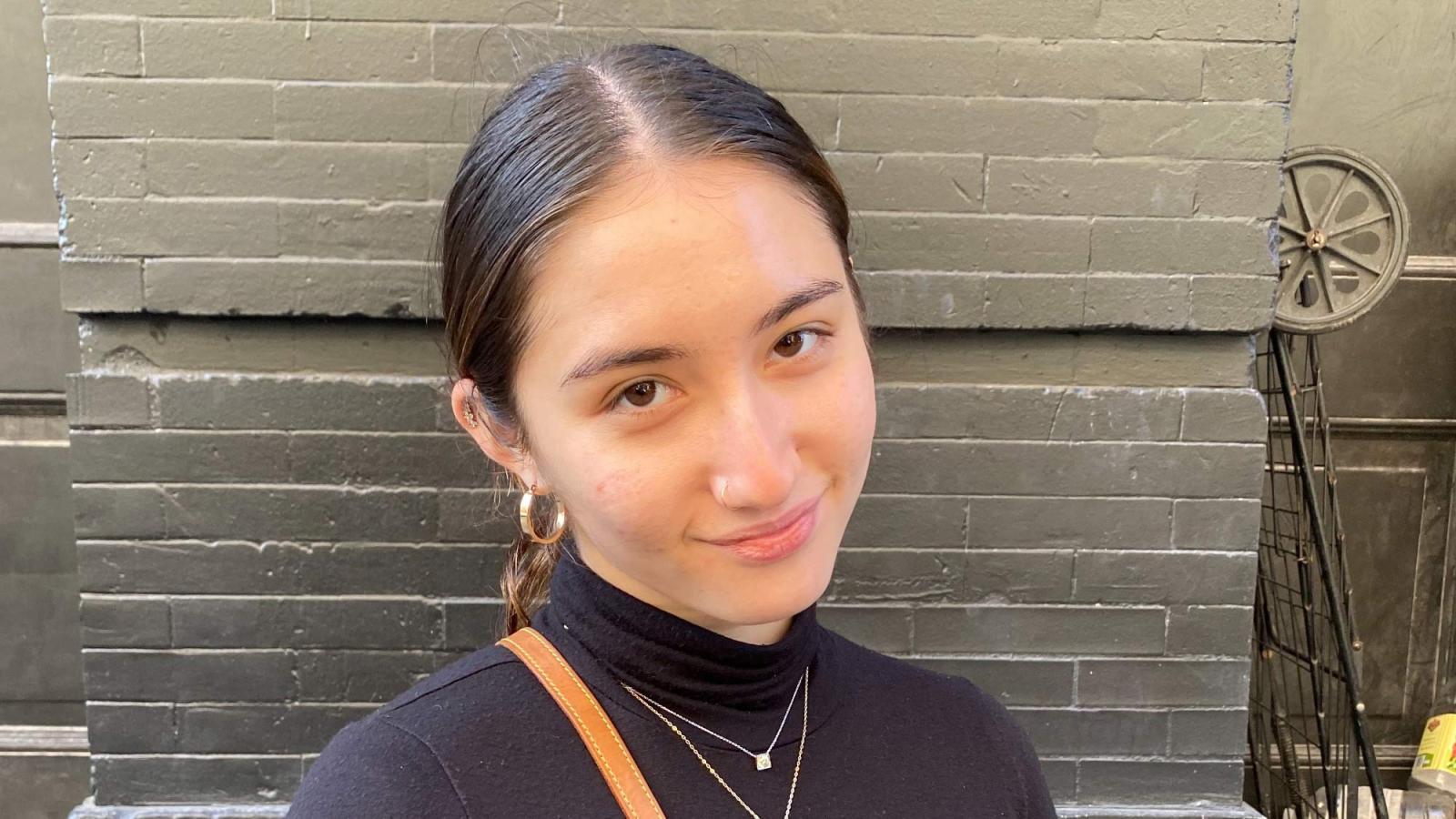 Mandi Karpo wears her hair pulled back and a black shirt and looks at the camera